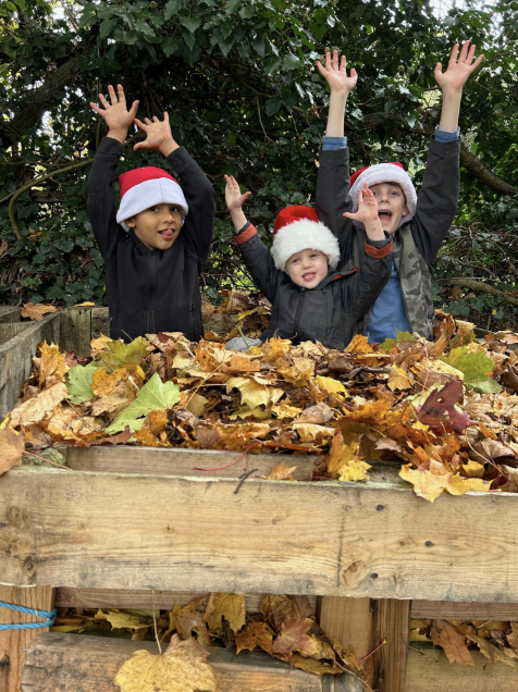 Three children posing wearing Santa hats